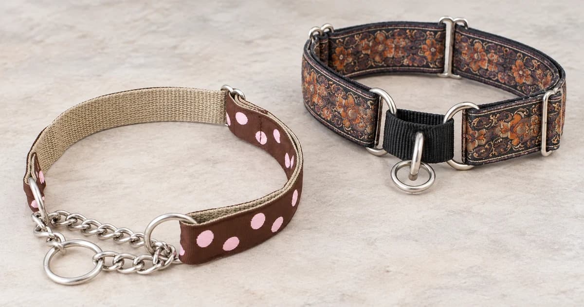 A brown and pink-dot chain martingale rests in front of a separate patterned fabric-loop collar on a pale tabletop.