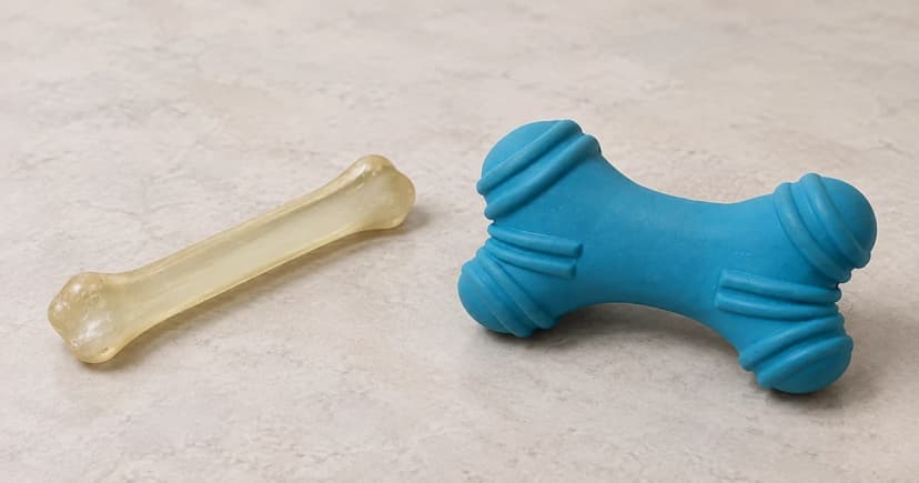 Photo-based edited pale elongated toy and separate blue ridged bone-shaped toy