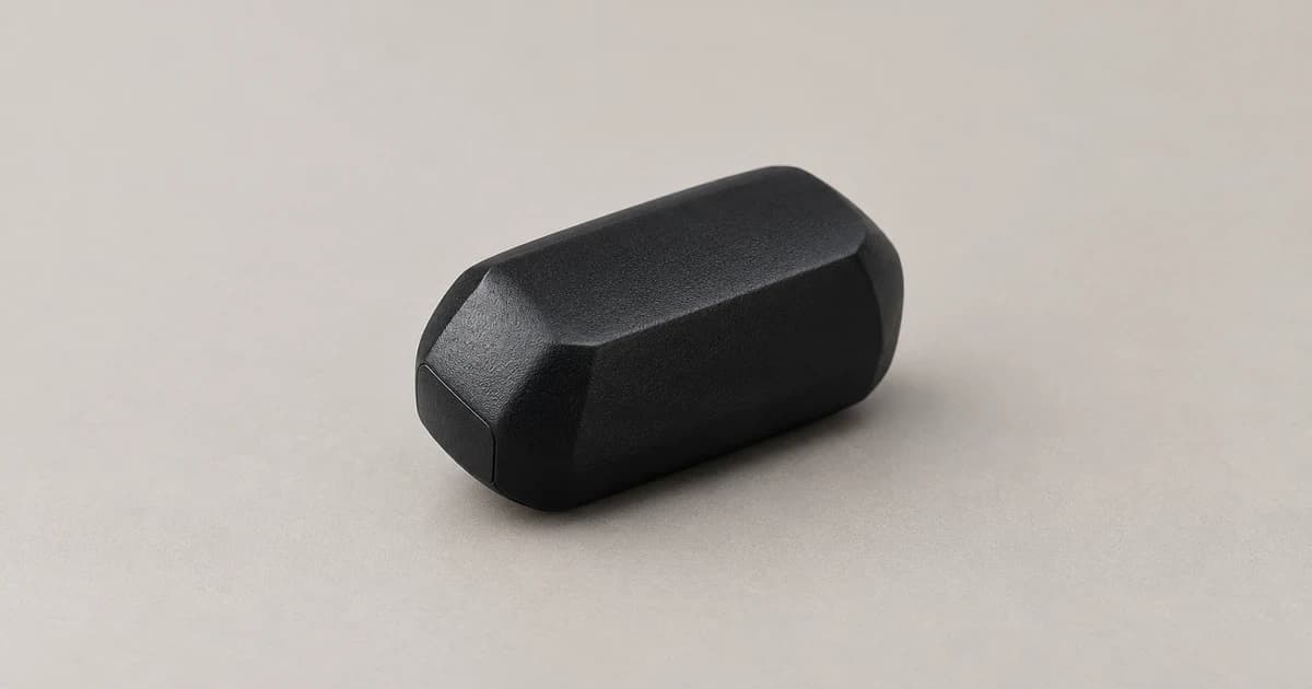 Reconstructed generic detached black tracker case resting on a neutral tabletop, with no animal or app shown.