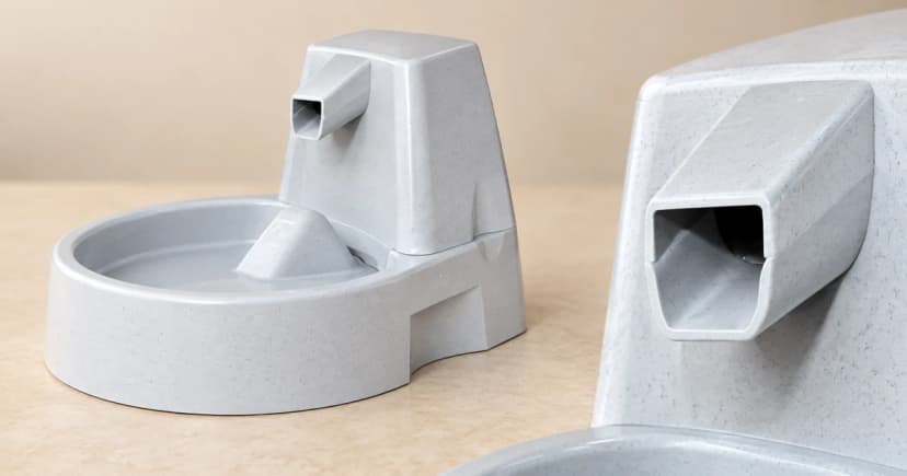 A gray fountain with a curved basin beside a separate close view of an angular gray outlet.