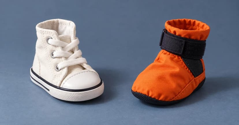 Edited illustration of a white lace-up dog shoe and an orange soft-looking dog boot