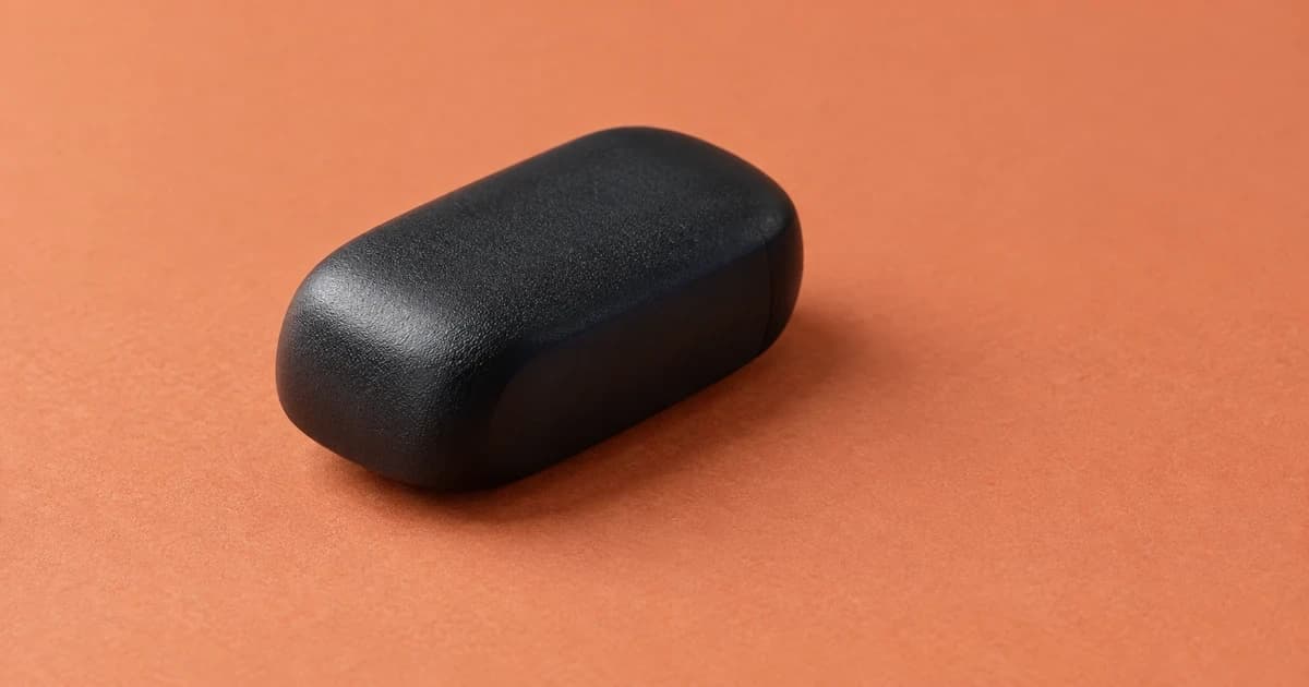 A rounded black case resting on a pale terracotta tabletop.