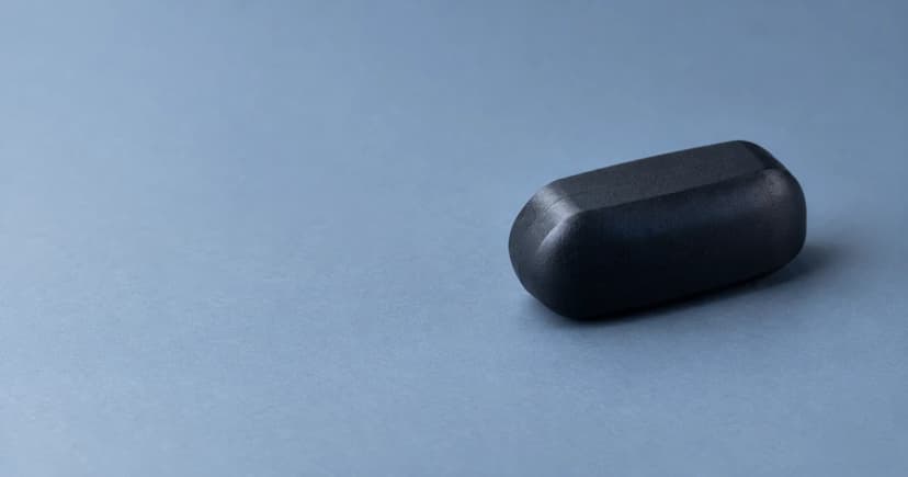 A single rounded black equipment case on a cool blue-grey tabletop.