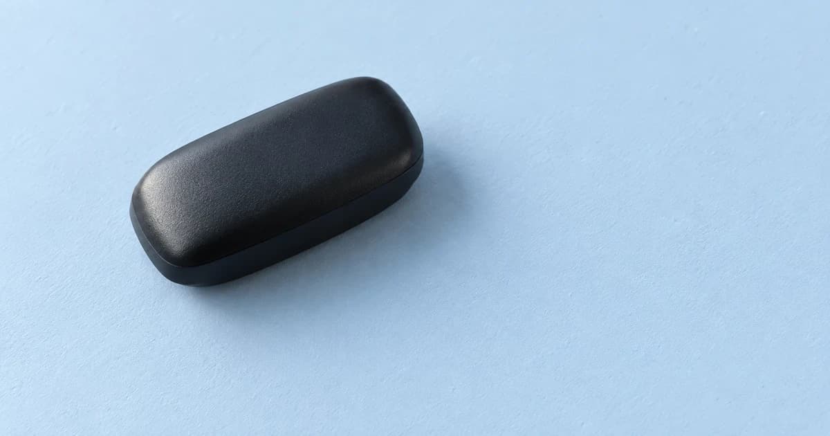A rounded black case resting diagonally on a light blue tabletop.