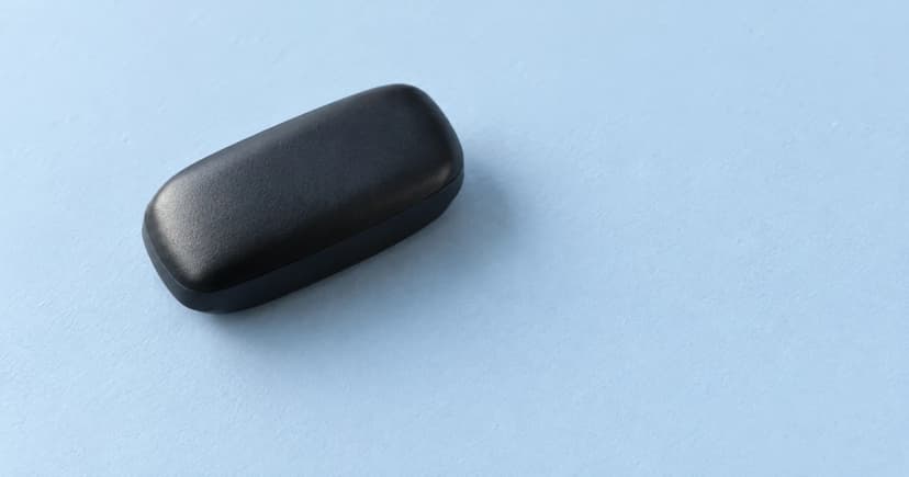 A rounded black case resting diagonally on a light blue tabletop.