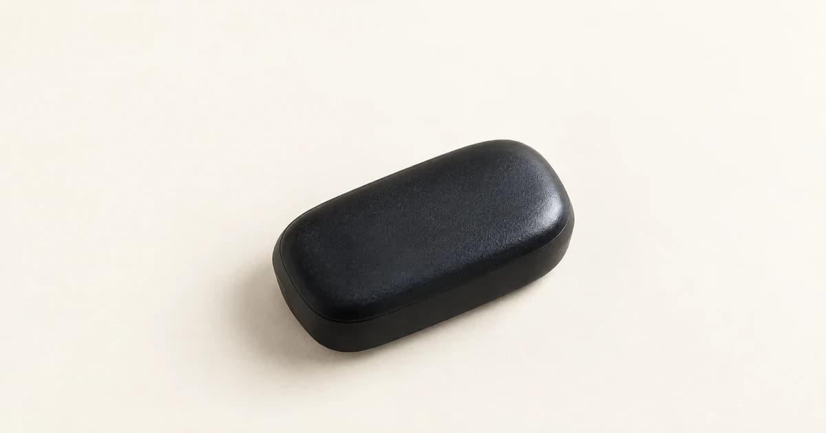 A single rounded black equipment case on a pale ivory tabletop.