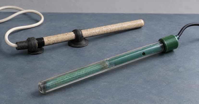 Two separate generic older glass aquarium heater exteriors on a studio tabletop.