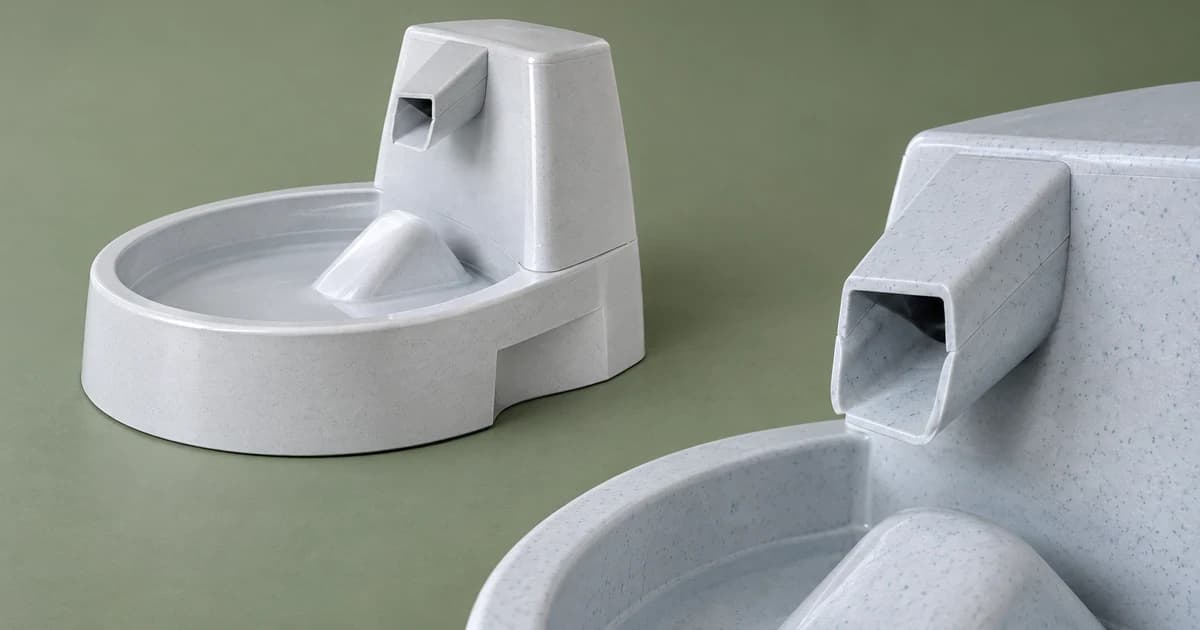 Gray fountain exterior and separate partial outlet on a sage-green tabletop.